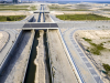 A view of the road networks and bridges going over a completed section of the Canal. The sand in the middle of the canal will soon be removed and roads will be constructed on both sides of the Canal
